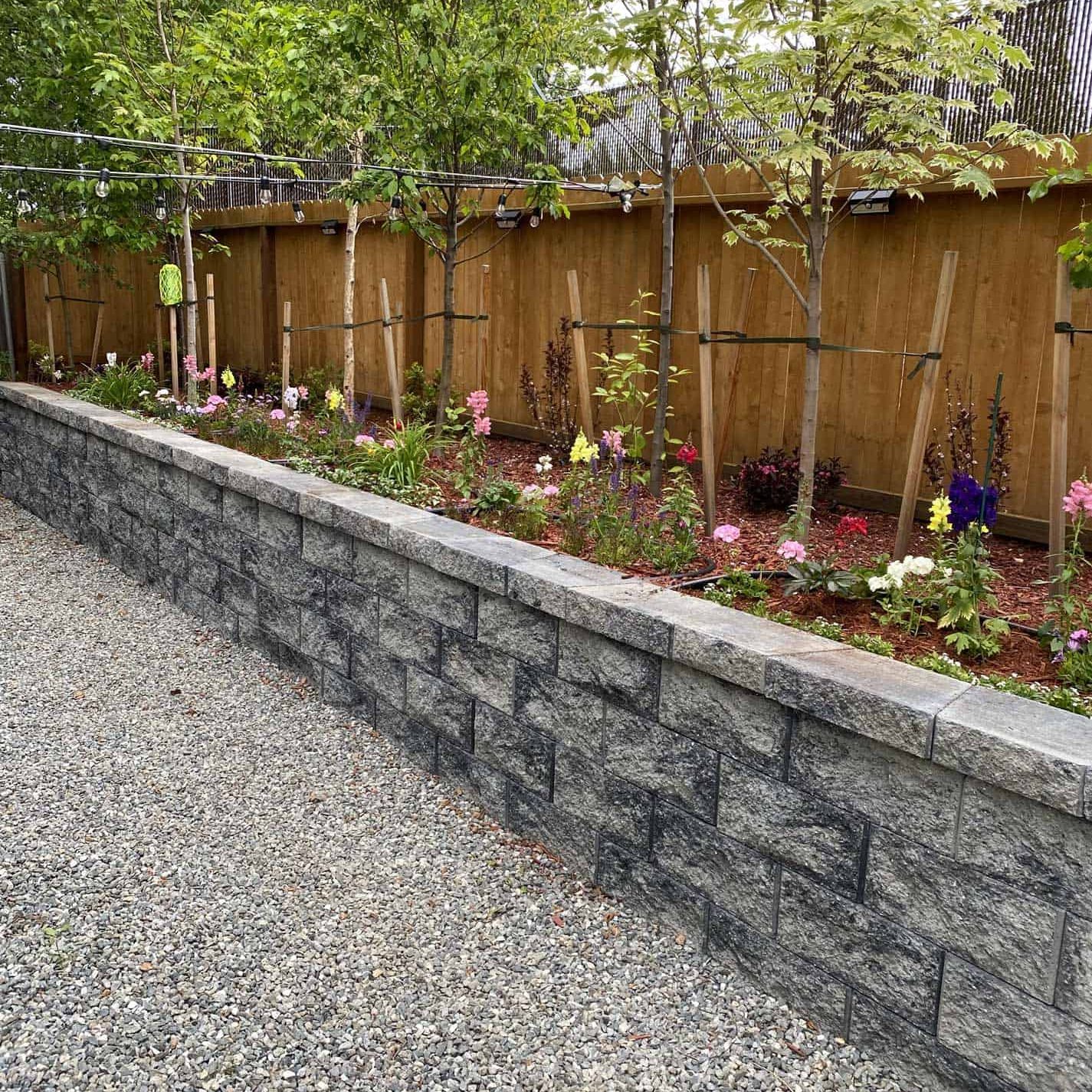 Beautiful garden with flower bed, wooden fence, and landscaping by Be Happy Property Services.
