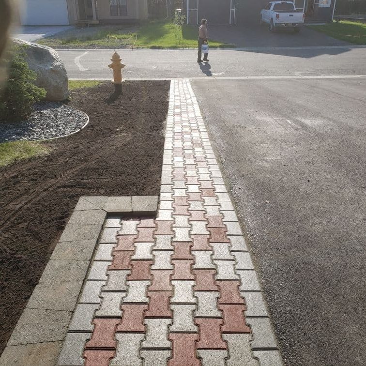 New decorative paver sidewalk installation in a residential area for enhanced curb appeal.