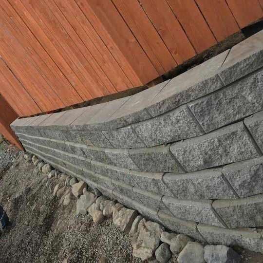 Wall construction with gray stone bricks for property enhancement.